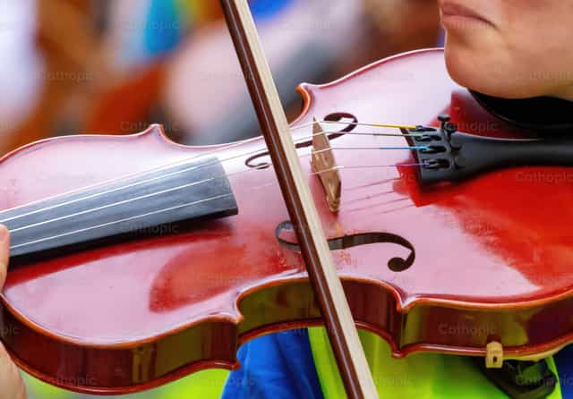 Músico tocando el violín durante un concierto en una orquesta - Banco de imágenes católicas - Fotografía por Antonio Gravante