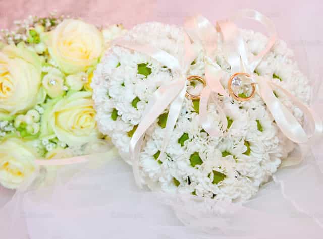 Wedding ornaments, ring on pillow in shape of heart - Catholic stock images - Photo by Antonio Gravante