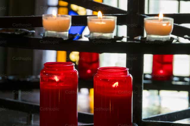 Fila di candele all’interno di una chiesa per la devozione o la preghiera - Immagini stock cattoliche - Foto di Joan Sutter