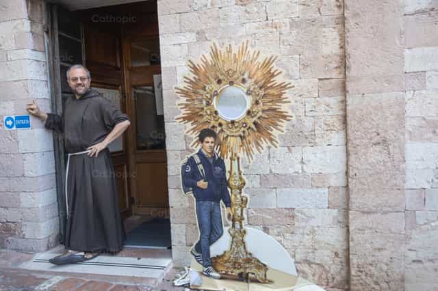 Fraile franciscano junto al retrato de Carlo Acutis - Banco de imágenes católicas - Fotografía por Yandry Fernández Perdomo