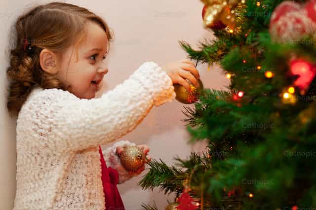 Hermoso niño cerca del árbol de Navidad. - Banco de imágenes católicas
