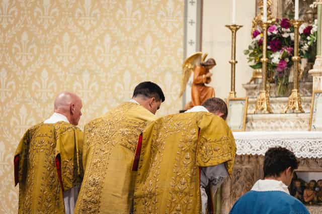 Sacerdote, diácono y subdiácono se inclinan - Banco de imágenes católicas