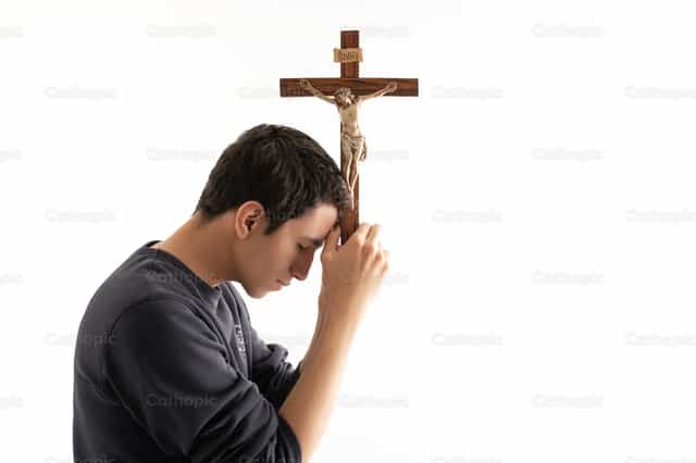 Young man adoring the cross - Catholic stock images - Photo by Clina CG