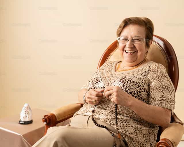 Abuelita feliz rezando el rosario - Banco de imágenes católicas - Fotografía por Clina CG
