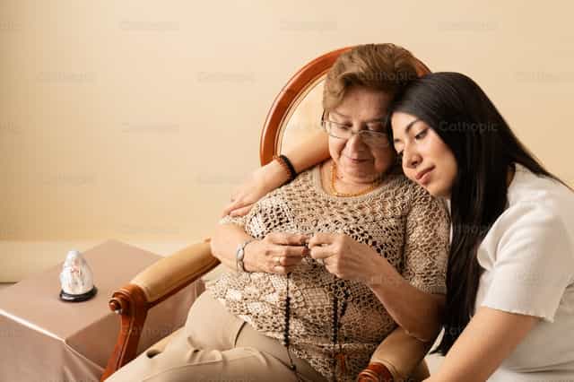Grandmother and granddaughter praying rosary - family union - Catholic stock images - Photo by Clina CG