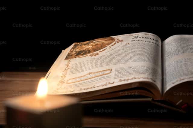 Antiga Bíblia sobre uma mesa de madeira com fundo escuro. - Imagens católicas de stock
