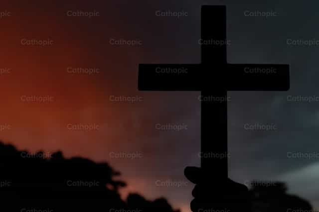 Silueta de una cruz sobre fondo de atardecer - Banco de imágenes católicas - Fotografía por Piero Insfran