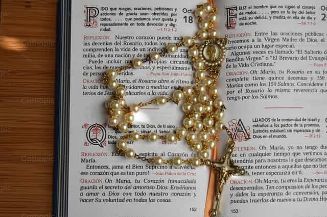 Una página de un libro de oraciones con un rosario - Banco de imágenes católicas - Fotografía por Luisa Oswalt