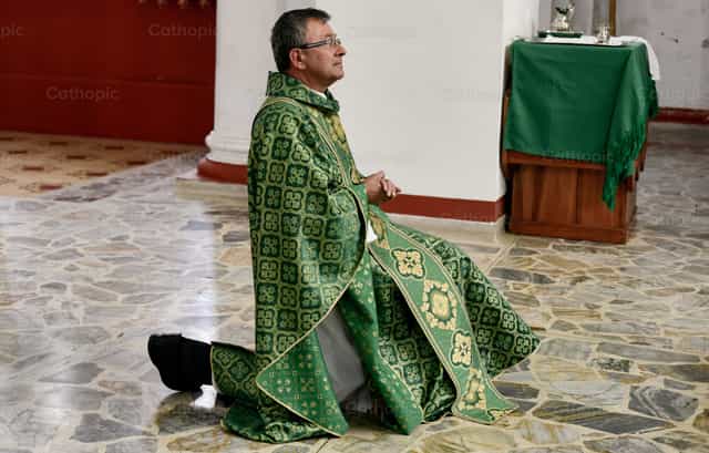 Sacerdote de rodillas - Banco de imágenes católicas - Fotografía por Carolina BR