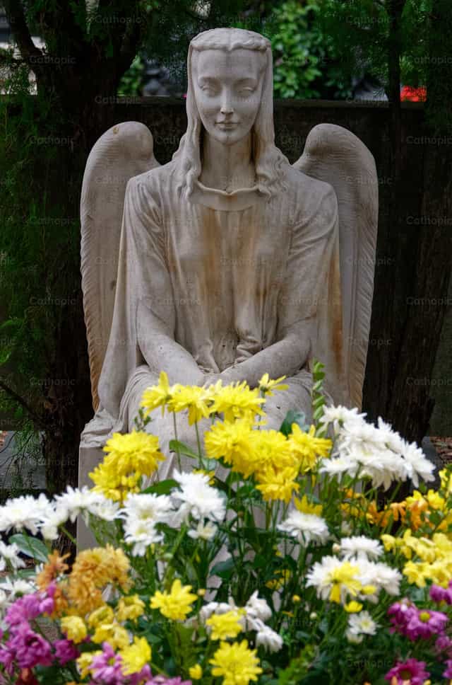 Angel protecting a flowering grave - Catholic stock images - Photo by Joan Sutter
