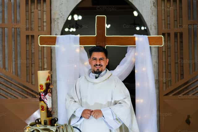 Sacerdote Joven sonriendo con la resurrección - Banco de imágenes católicas - Fotografía por Miguel White