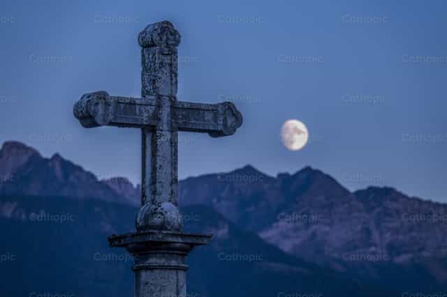 Stone cross with moonrise - Catholic stock images - Photo by Joan Sutter