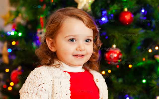 Hermosa niña pequeña junto al árbol de Navidad - Banco de imágenes católicas - Fotografía por Antonio Gravante
