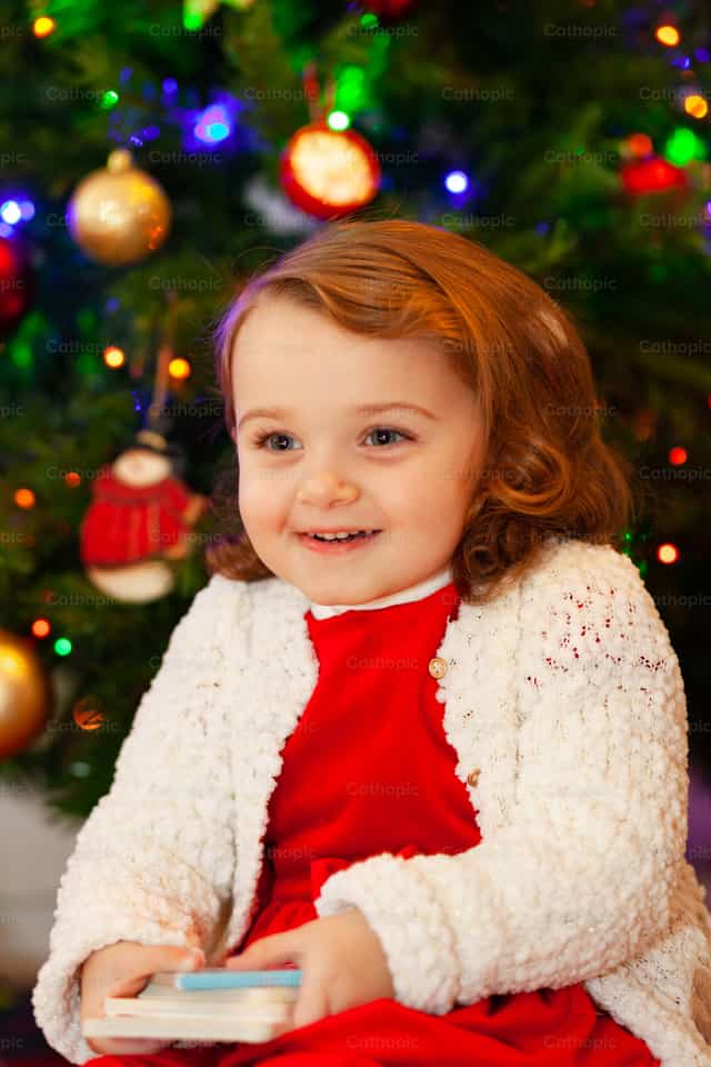 Hermosa niña pequeña junto al árbol de Navidad - Banco de imágenes católicas - Fotografía por Antonio Gravante