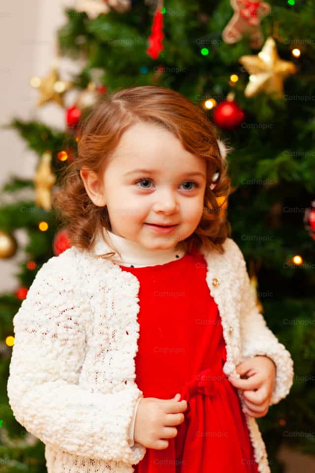Hermosa niña pequeña junto al árbol de Navidad - Banco de imágenes católicas - Fotografía por Antonio Gravante