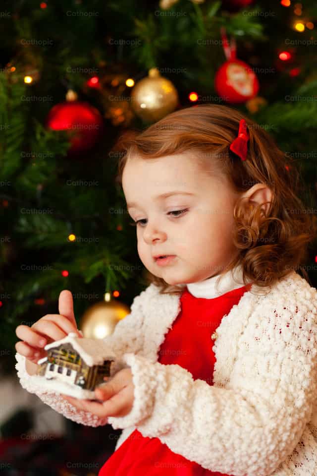 Beautiful little child near Christmas tree - Catholic stock images - Photo by Antonio Gravante