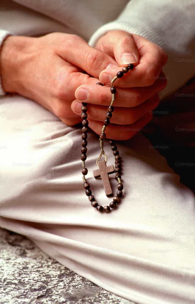 Hands holding rosary - Catholic stock images - Photo by Joan Sutter
