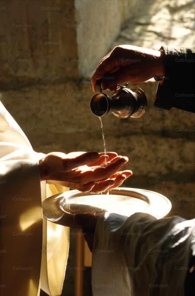 Agua vertida sobre las manos del sacerdote. - Banco de imágenes católicas - Fotografía por Joan Sutter