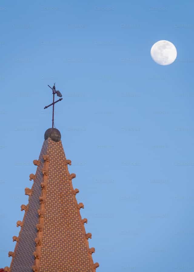 La torre de la iglesia y la luna en un cielo tranquilo - Banco de imágenes católicas - Fotografía por Joan Sutter