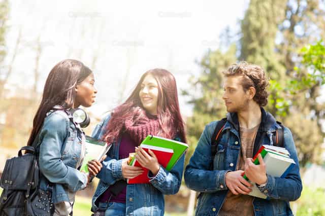 Tres estudiantes en el parque al aire libre. - Banco de imágenes católicas