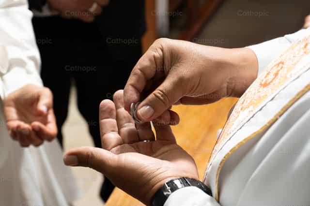 Arras en las manos del sacerdote - Banco de imágenes católicas - Fotografía por Clina CG
