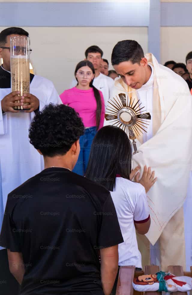 Joven adora a Jesus Eucaristia - Banco de imágenes católicas