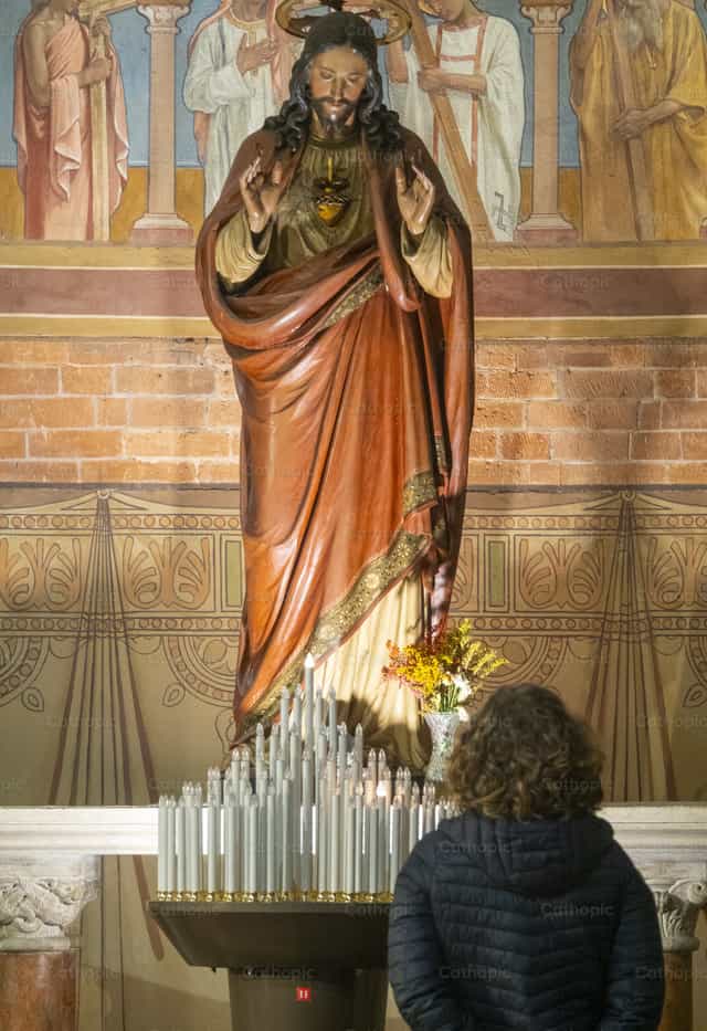 Rezar delante del Sagrado Corazón de Jesús - Banco de imágenes católicas - Fotografía por Joan Sutter