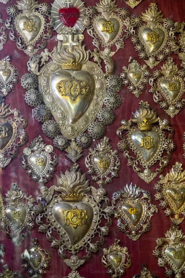 Conjunto de ex-votos em uma igreja - Imagens católicas de stock - Foto de Joan Sutter