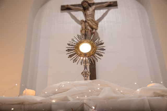 The Blessed Sacrament exposed before Christ crucified - Catholic stock images - Photo by Yandry Fernández Perdomo