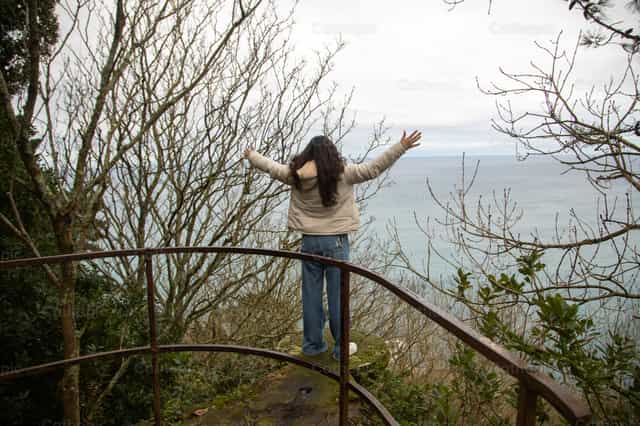 Mujer joven agradeciendo a Dios en la naturaleza - Banco de imágenes católicas