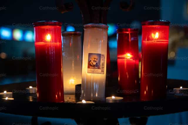 Velas encendidas con la imagen del Padre Pío - Banco de imágenes católicas - Fotografía por Yandry Fernández Perdomo