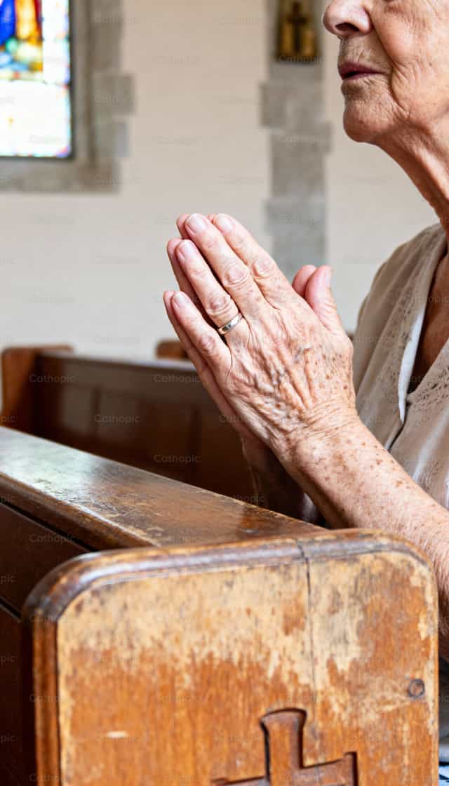 Ancienne dévotion : mains priantes près de la fenêtre vitrée - Images catholiques de stock