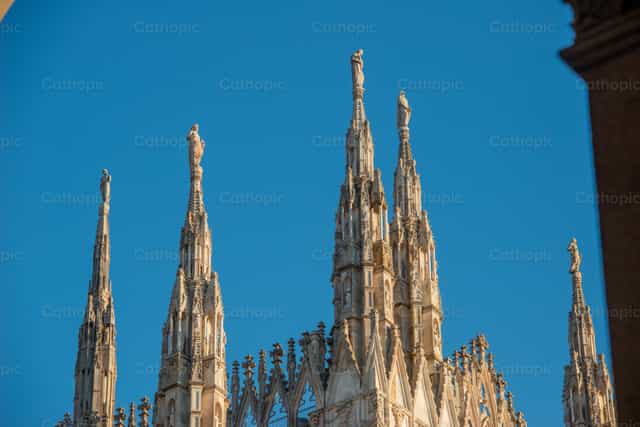 Las agujas de la catedral de Milán bajo el cielo azul. - Banco de imágenes católicas - Fotografía por Pierluigi Palazzi