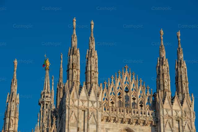 Las agujas de la catedral de Milán bajo el cielo azul. - Banco de imágenes católicas - Fotografía por Pierluigi Palazzi