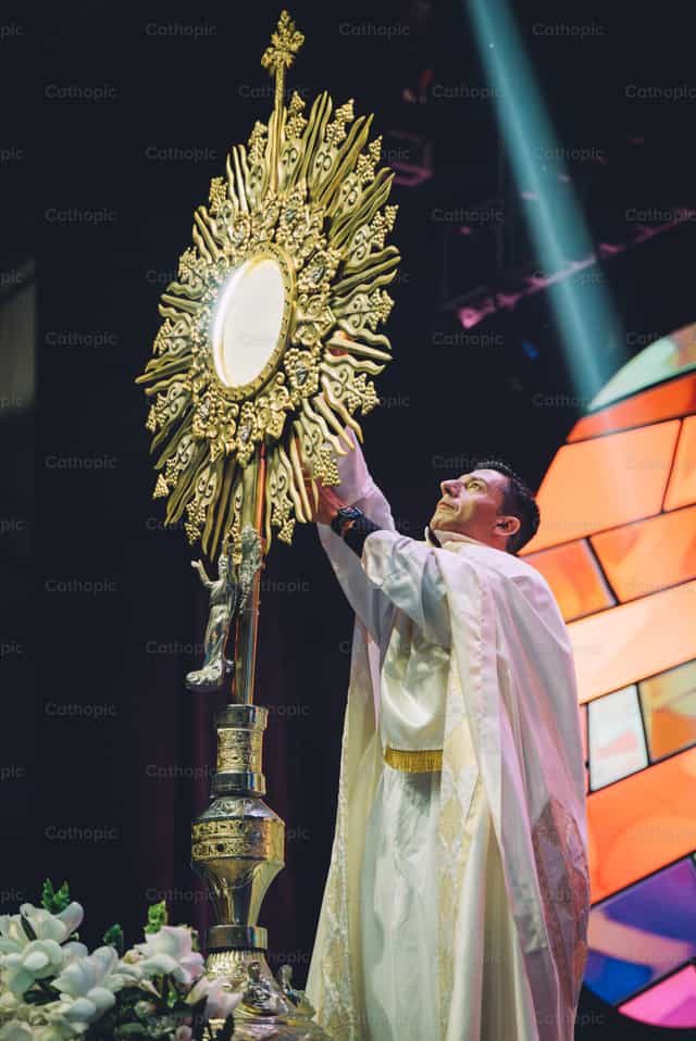 Prêtre devant l’ostensoir - Images catholiques de stock