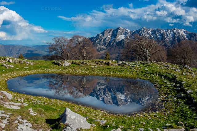 Estanque donde se reflejan las montañas nevadas. - Banco de imágenes católicas - Fotografía por Pierluigi Palazzi