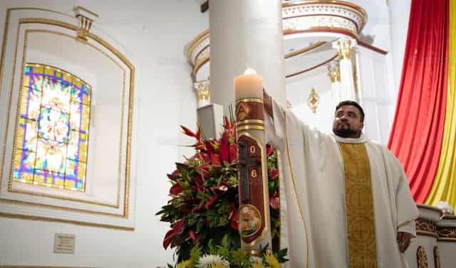 Um sacerdote acendendo a vela pascal - Imagens católicas de stock - Foto de Carolina BR