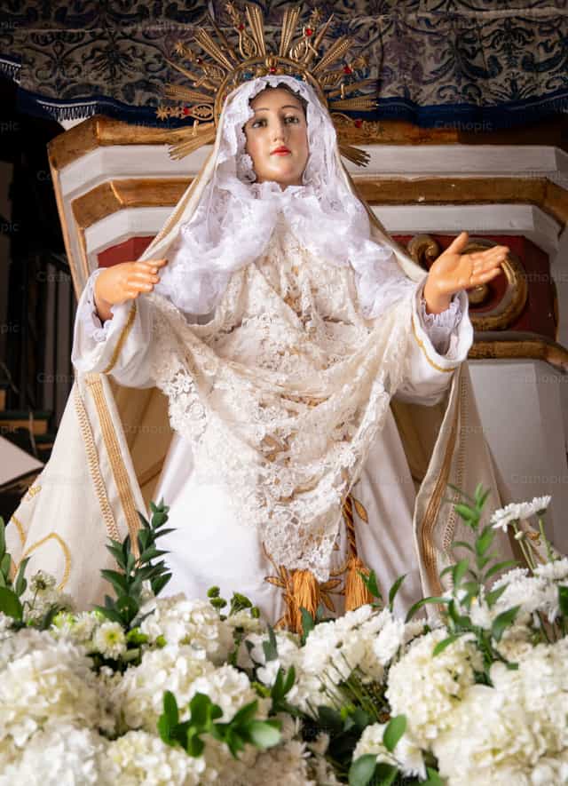 Virgen María en altar con flores blancas - Banco de imágenes católicas - Fotografía por Carolina BR