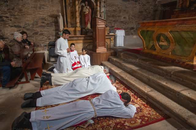 Priests kneeling before the altar on Good Friday - Catholic stock images - Photo by Yandry Fernández Perdomo