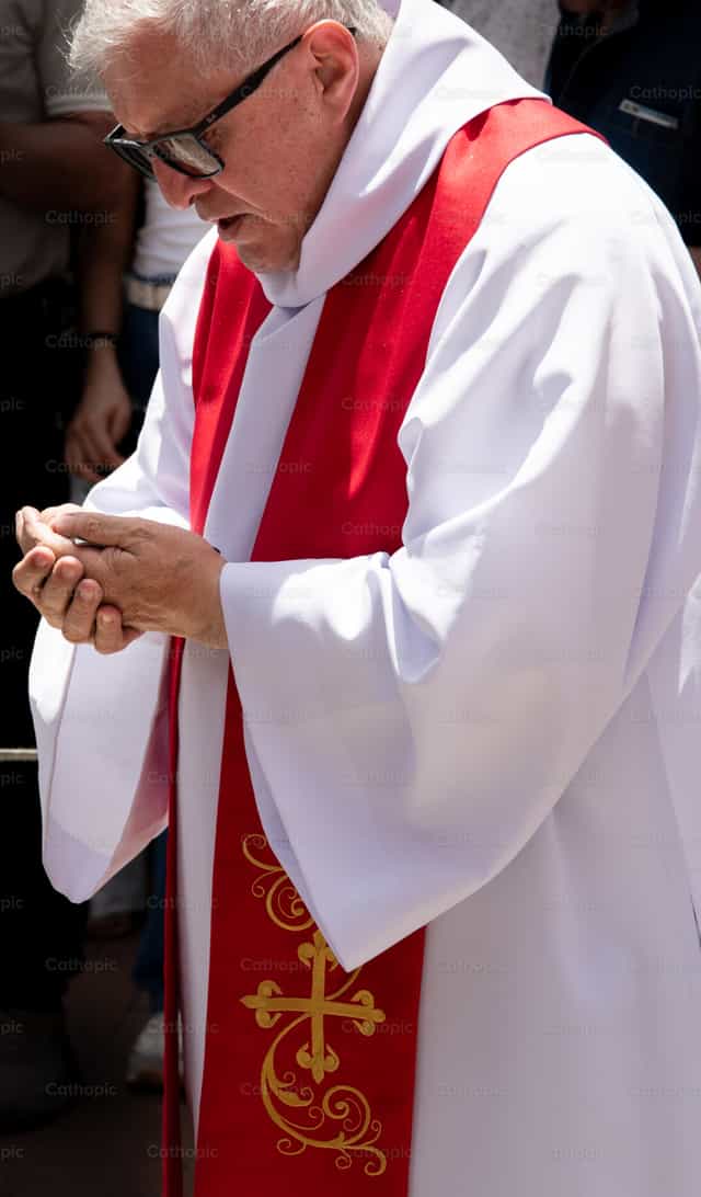 Sacerdote en oración durante procesión - Banco de imágenes católicas - Fotografía por Carolina BR