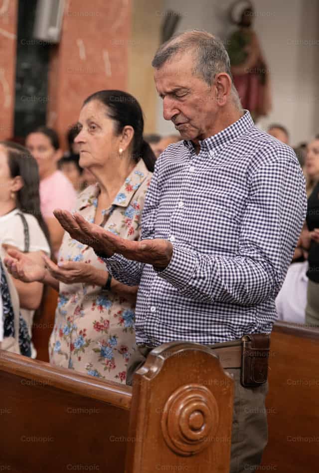 Fiel en gesto de oración comunitaria - Banco de imágenes católicas - Fotografía por Carolina BR