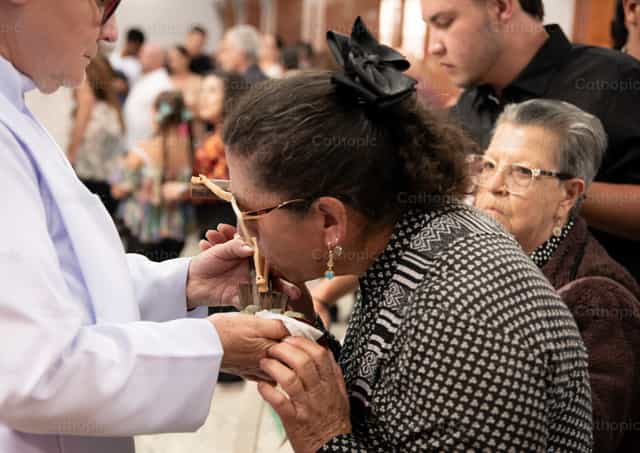 Fiel besa crucifijo en gesto de veneración - Banco de imágenes católicas