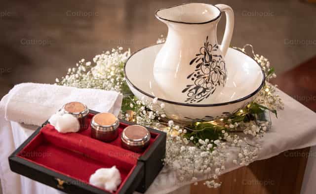 Óleos y jarra en mesa de bautismo - Banco de imágenes católicas - Fotografía por Carolina BR