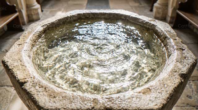 Pia batismal de pedra com água límpida e ondulações - Imagens católicas de stock