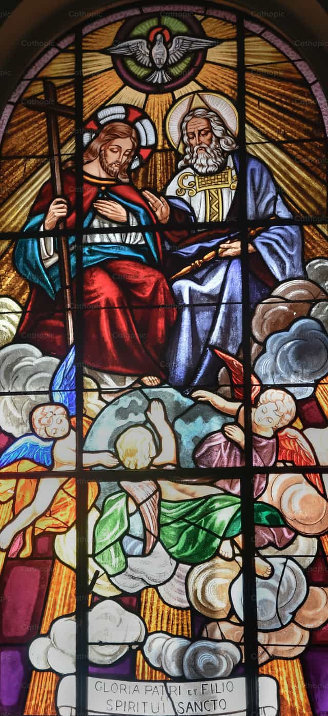 La vidriera de la Santísima Trinidad bañada en luz dorada - Banco de imágenes católicas - Fotografía por Carolina BR