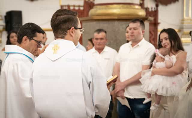 Famiglia durante una cerimonia di battesimo - Immagini stock cattoliche