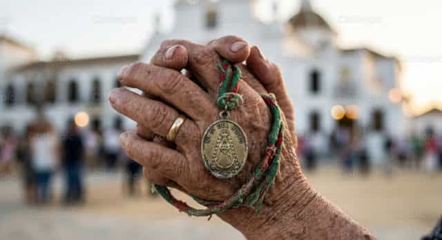 Mga kamay na nakapulupot sa panalangin na may relihiyosong medalya - Mga Catholic stock image - Larawan ni Clara González-Rojas