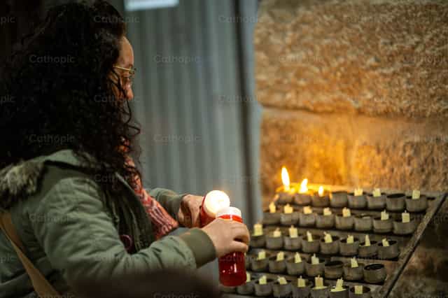 Fieles colocando velas dentro de iglesia - Banco de imágenes católicas
