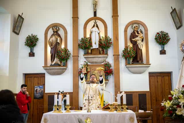 Sacerdote eleva la Eucaristía - Banco de imágenes católicas - Fotografía por Yandry Fernández Perdomo