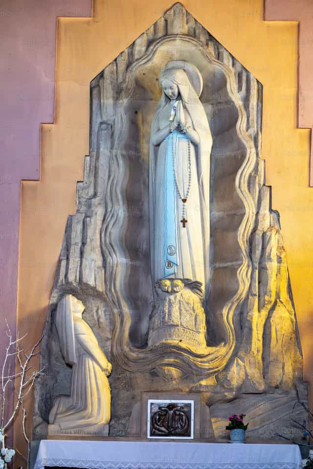 Oratory with a statue of Apparition of the Virgin Mary, Our Lady of Lourdes to Bernadette Soubirous. Bernadette Soubirous, - Catholic stock images - Photo by Joan Sutter